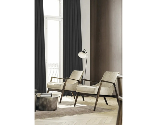 Woonkamer met twee fauteuils, een staande lamp en gordijnen voor een gezellige sfeer