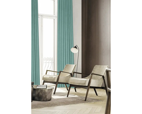 Woonkamer met gordijnen, fauteuils en vloerlamp