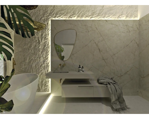 Moderne badkamer met ligbad, wastafelonderkast, spiegel en wandbekleding in natuursteenlook.