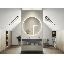 Lichte zolderbadkamer met ronde spiegel met verlichting, wastafel, wasmachine en inbouwkasten