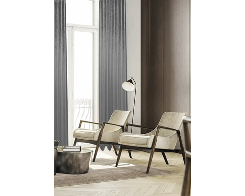 Woonkamer met twee fauteuils, een staande lamp en gordijnen