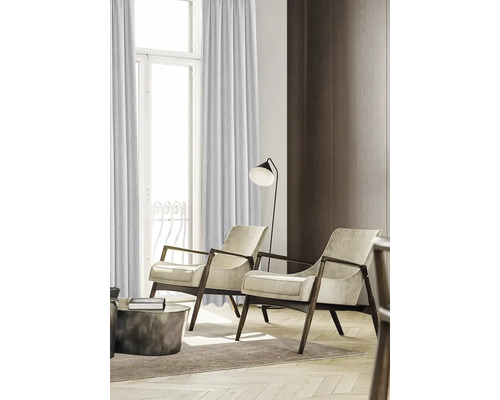 Woonkamer met gordijnen, twee fauteuils en een vloerlamp