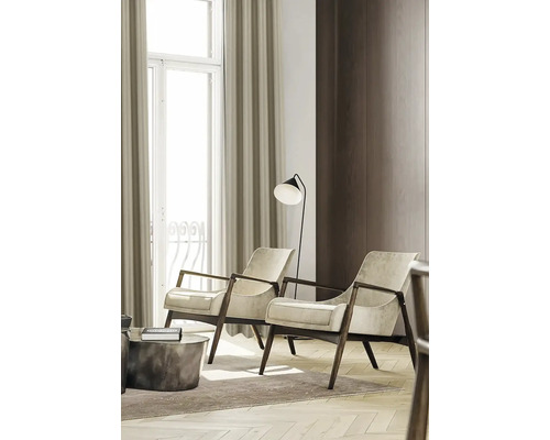 Woonkamer met twee fauteuils, een vloerlamp en gordijnen