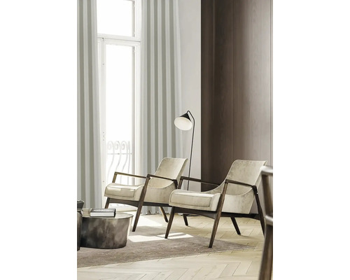 Twee fauteuils met houten frame in een lichte woonkamer.