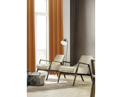 Woonkamer met twee fauteuils, een vloerlamp en gordijnen voor het raam.