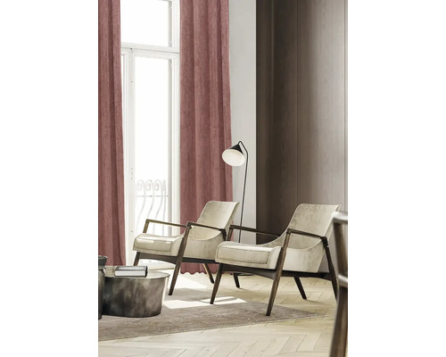 Lichte, vriendelijke inrichting met gordijnen, fauteuils en een staande lamp