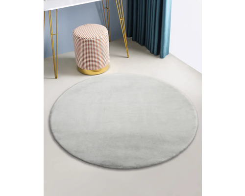 Rond, zacht vloerkleed in interieur met kruk en tafel