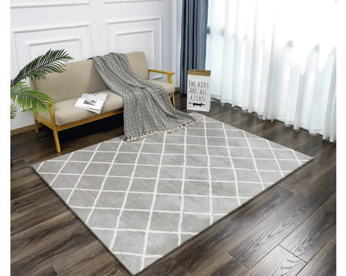 Woonkamer met vloerkleed met ruitpatroon, bank en gordijnen