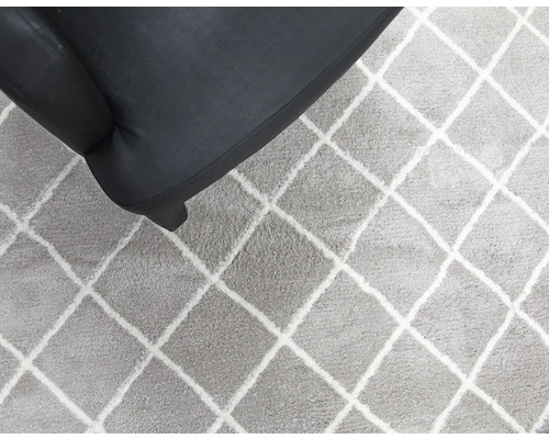 Vloerkleed met ruitpatroon naast een fauteuil