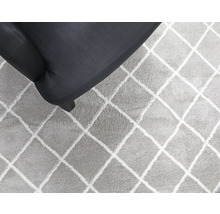 Vloerkleed met ruitpatroon naast fauteuil