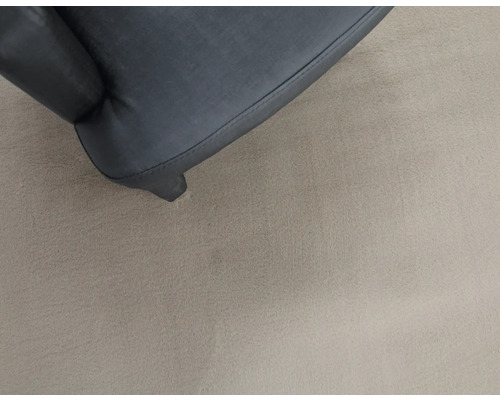 Detailopname van een meubelstuk met bekleding en poten.