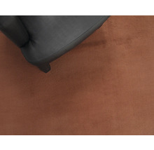 Detailweergave van een zwarte fauteuil op een vloerkleed
