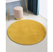 Geel rond tapijt in de kamer met tafel en kruk