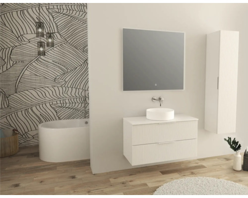 Badkamer met bad, wastafel, spiegel en hoge kast