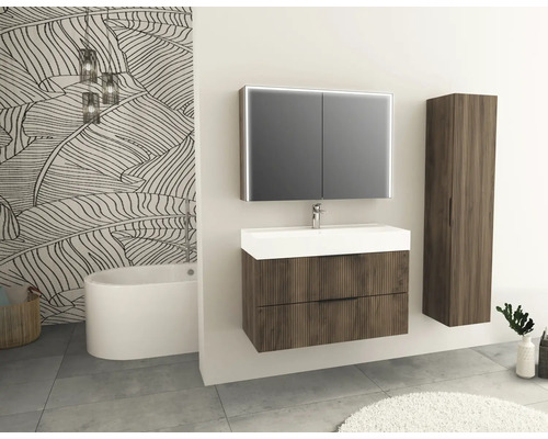 Badkamer met wastafel, spiegelkast, kolomkast en bad voor een behang met print