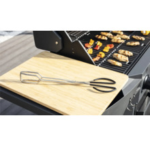 Barbecuescène met barbecue-tang, snijplank, barbecuegerechten