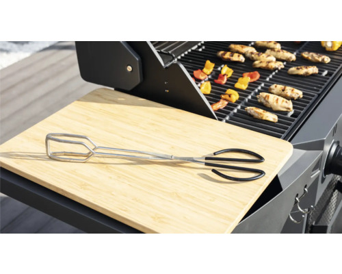 Barbecuescène met barbecue-tang, snijplank, barbecuegerechten