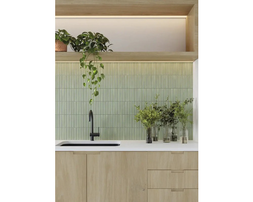 Keukenscène met gootsteen, kraan, werkblad, groene tegelachterwand en kamerplanten