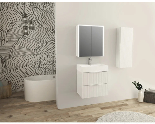 Lichte badkamer met wastafelmeubel, spiegelkast, hangkast en badkuip tegen een muur met bladerpatroon.