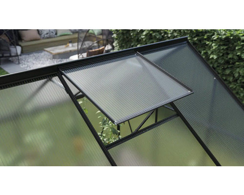 Detailopname van een kas met een open raam voor ventilatie.