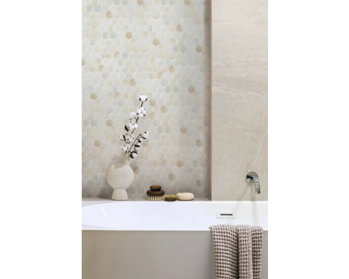 Badkamer met zeshoekige wandtegels en ligbad