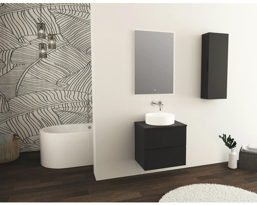 Badkamer met wastafel, spiegel, hangkast en vrijstaand bad tegen een muur met bladmotief