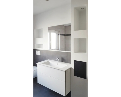 Moderne badkamer met witte wastafel, spiegel en geïntegreerde planken