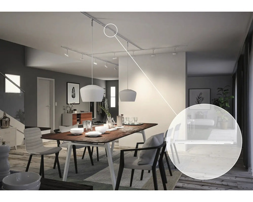 Woonkamer met eettafel en plafondlampen aan stroomrails