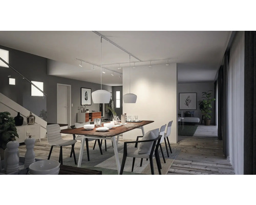 Lichte eetkamer met houten tafel, stoelen en moderne verlichting.
