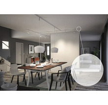 Eetkamer met eettafel, stoelen, hanglampen en stroomrailsysteem aan het plafond