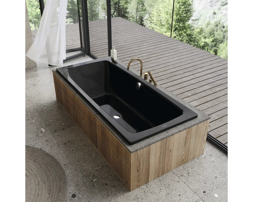 Zwarte badkuip met houten bekleding en gouden kraan in een moderne badkamer.