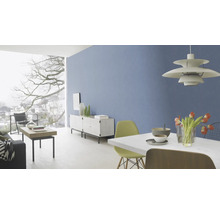 Lichte woonkamer met blauwe muur, eettafel, stoelen, dressoir en groot raam