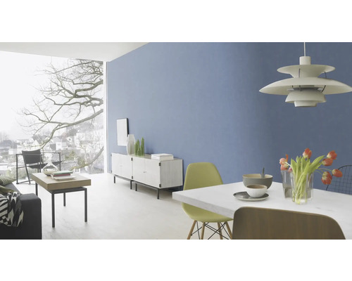 Lichte woonkamer met blauwe muur, eettafel, stoelen, dressoir en groot raam