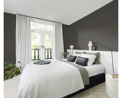 Lichte slaapkamer met tweepersoonsbed, gordijnen en kamerplanten