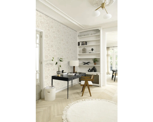 Een lichte werkruimte met bloemenbehang, een zwart bureau en een rond vloerkleed