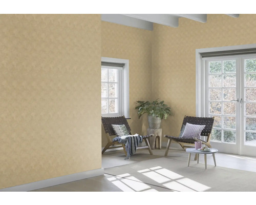 Woonkamer met patroonbehang, stoelen en plant.