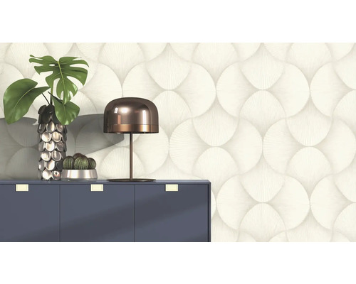 Decoratief behang met cirkelpatroon achter een dressoir met lamp en planten