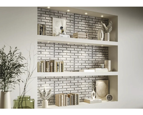 Decoratieve wandbekleding met steenpanelen in een woonkamerrek met boeken en vazen