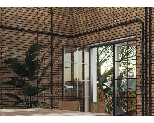 Interieur met bakstenen muur, leidingen en een deur met glas