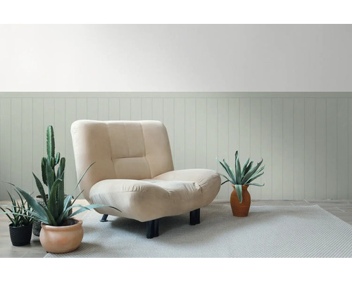 Beige fauteuil met planten en vloerkleed voor een wand met houten lambrisering