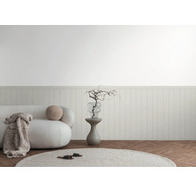Licht interieur met bank, bijzettafel en decoratieve elementen tegen een lambrisering.
