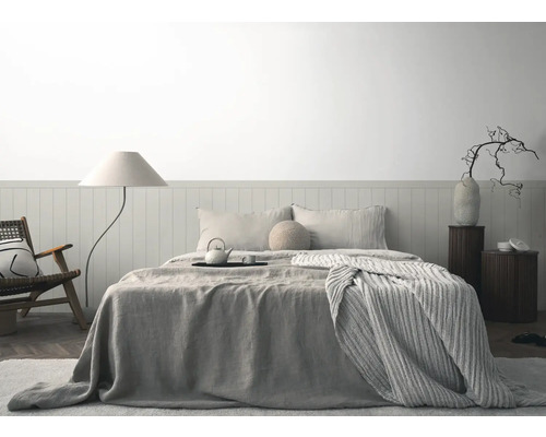 Lichte slaapkamer met bed, nachtkastjes, staande lamp en fauteuil