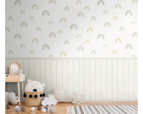 Kinderkamer met regenboog behangpatroon, lambrisering en diverse decoratieve artikelen.