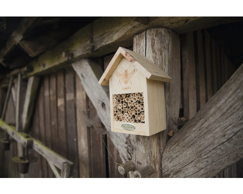 Houten insectenhotel met bamboe buizen op een houten paal