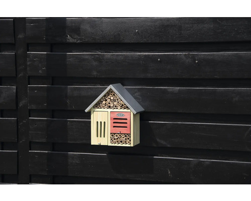 Houten insectenhotel aan een donkere houten muur