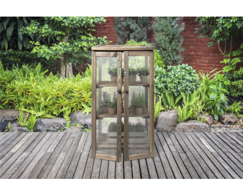 Houten tuinkast met planken en glazen deuren in de tuin