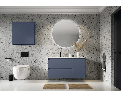 Moderne badkamer met wastafel, spiegelkast en toilet tegen een muur met steenmotief