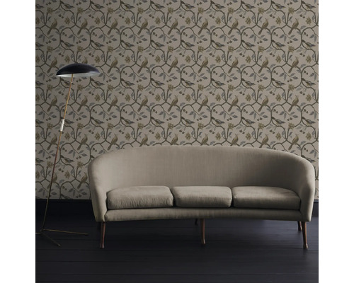 Woonkamer met behang met vogelmotief, bank en vloerlamp.