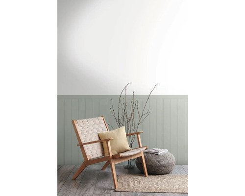 Woonkamer met houten fauteuil, kussen, kruk en vloerkleed