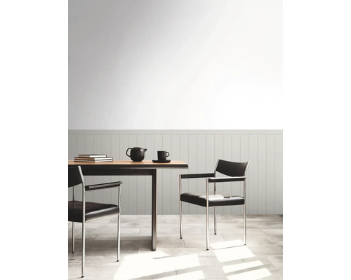 Eettafel met stoelen, theepot en kopje in een lichte kamer.